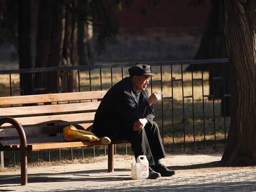 Idoso chins sozinho em parque no centro de Beijing